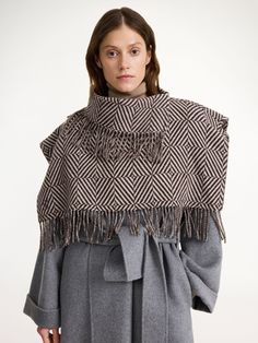 Forgo the classic scarf this season and opt for the bohemian bib. With its plush fringe trims, wide shoulders, and wool fabrication, the Turtlas design will add elegance and warmth to your outerwear edit. It’s key detail? The small, embroidered monogram in its front. Chic Wool Poncho For Winter, Winter Shawl With Tassels, Chic Cashmere Shawl, Elegant Fringed Scarves For Fall, Chic Oversized Shawl For Winter, Chic Oversized Winter Shawl, Winter Fringe Shawl Outerwear, Cashmere Outerwear With Scarf For Fall, Fall Cashmere Outerwear With Scarf