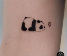 a small panda bear tattoo on the side of a woman's leg with a butterfly