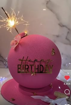 a pink birthday cake with sparklers on top and the words happy birthday written on it