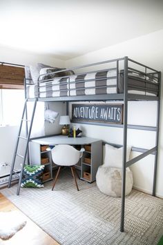 a loft bed with desk underneath it in a small room next to a white chair