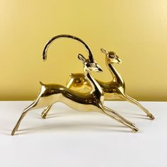 two golden deer figurines sitting side by side