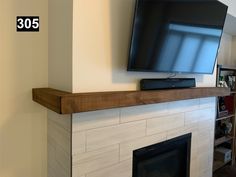 a flat screen tv mounted on top of a fireplace