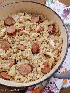 a pan filled with rice and sausage on top of a table