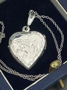 Vintage  silver locket for women. Double sided silver locket with hand engraved back and front. Double photo locket.   Silver heart locket. Silver pendant . Silver necklace for women.       Vintage circa 70s. Condition: necklace in perfect vintage condition. Materials: Silver. Rhodium plated silver chain.  Measure: chain 16"/ 41 cm,   Locket  0.7" x 0.7"/  1.8 x 1.8 cm. Package: gift wrap available, please specify when ordering. Delivery: your order will be send by Royal Mail with tracking and s Silver Locket For Valentine's Day, Silver Round Locket Necklace For Valentine's Day, Silver Locket Necklace For Valentine's Day, Silver Engraved Necklace For Anniversary, White Gold Pendant Locket Necklace Gift, Silver Jewelry For Mother's Day Keepsake, Victorian Hallmark Locket Necklace Gift, Victorian Locket Necklace With Hallmark As Gift, Vintage Necklaces With Engraving Option For Anniversary