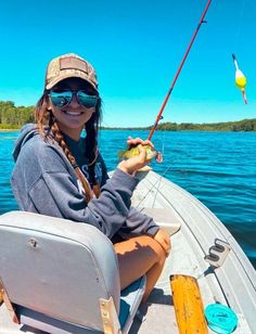 a woman is sitting on a boat fishing