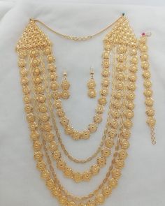 a gold necklace and earring set on display