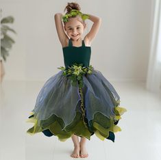 Unleash her inner forest fairy with this magical Woodland Forest Fairy Costume. Crafted with layers of delicate ruffled organza in enchanting shades of green, this dress captures the essence of a whimsical woodland adventure. The dress features a detachable sash adorned with a charming mix of leaves and flowers, adding a touch of nature's beauty to her outfit. A matching headband, decorated to complement the dress, completes the look. Perfect for school dress-up days, enchanting photoshoots, or magical birthday celebrations, this costume promises to make her fairy tale dreams come true. Size Guide: 1) All our Gowns can be made in any size ranging from girls 3-6 months to Adult Plus Sizes. 2) Ordering based on Size Chart: Before you place your order please compare your measurements to the s Pregnant Mother Nature Costume, Woodland Fairy Costume Kids, Fairy Costumes For Kids, Fairy Costume Ideas Diy, Woodland Outfit, Dark Fairy Costume, Forest Fairy Costume, Woodland Fairy Costume, Mother Nature Costume