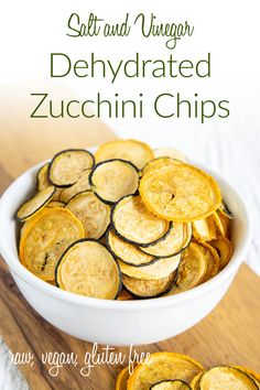 sliced zucchini chips in a white bowl on a wooden cutting board with text overlay