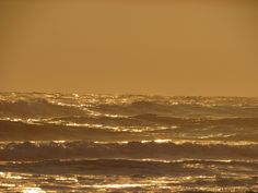 a person riding a surfboard in the ocean at sunset