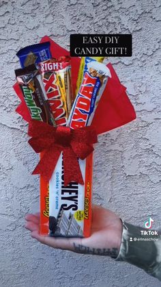 someone is holding up a candy gift in front of a wall with the words easy diy candy gift written on it