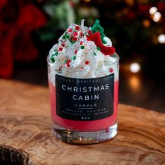 a small glass cup filled with whipped cream and sprinkles sitting on top of a wooden table