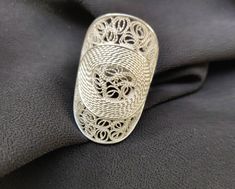 This lovely chunky Silver 925 Filigree statement ring has an inner donut design and is embellished with filigree lace. A handcrafted piece, this ring is stunning and will be sure to make a statement. Description: *  Handmade silver filigree ring *  Oval shape with filigree lace with inner donut lace design *  Adjustable   *  Head Width: approx. 25mm *  Head length: approx. 33mm *  Worldwide shipping Handmade Silver Filigree Ring As Gift, Handmade Silver Filigree Ring Gift, Handmade Oval Filigree Ring For Gift, Donut Design, Dragonfly Pendant, Ring Oval, Star Ring, Filigree Ring, Silver Filigree