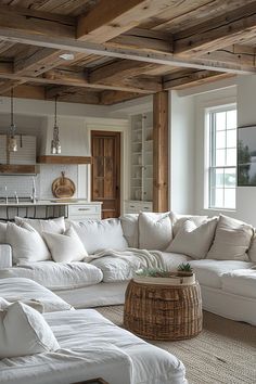 a living room filled with white furniture and lots of pillows on top of the couches