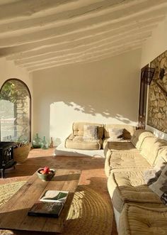 a living room filled with furniture and a stone wall