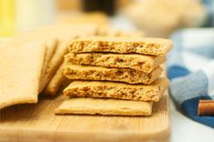 a stack of crackers sitting on top of a wooden cutting board next to cinnamon sticks