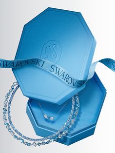 a blue box with a necklace in it that says swarovs on the side