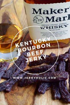 a wooden cutting board topped with beef strips next to a bottle of whiskey