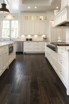 a large kitchen with white cabinets and wood floors