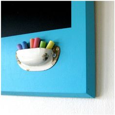 an image of a blue frame with some colorful pens and markers attached to the wall