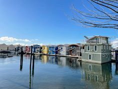 a row of houses sitting on top of a body of water next to a dock