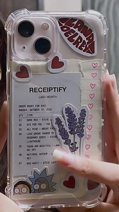 a person holding up a phone case with stickers on it