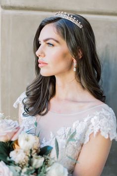 a woman wearing a tiara and holding a bouquet