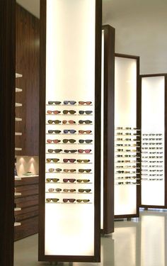 an eyeglass display in a store with lots of glasses on the wall behind it