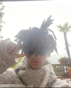 a person with dreadlocks and sunglasses on