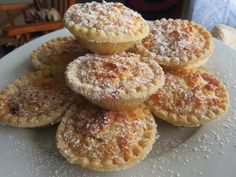 a white plate topped with mini pies covered in powdered sugar on top of a table