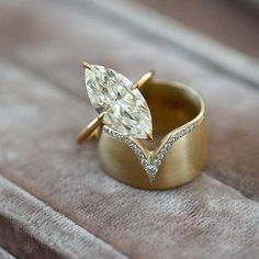 a gold ring with a pear shaped diamond on it