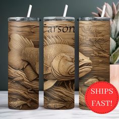 three wooden tumblers with fish on them, one has a straw in it and the other is empty