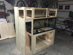 a wooden cabinet with glass doors in a garage