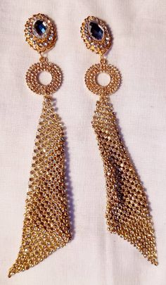 Large style These hang 6 inches Handmade originals Gold and rhinestone metal clip on Very unique gold metal mesh design Very blingy and cute These are very lightweight on the ear Easy to wear Statement style They are one of a kind These Earrings are a classic and timeless addition to any wardrobe Gold Crystal Jewelry With Rhinestone Fringe, Glamorous Gold Rhinestone Fringe Jewelry, Glamorous Gold Jewelry With Rhinestone Fringe, Gold-tone Metal Clip-on Earrings For Party, Gold Rhinestone Fringe Metal Jewelry, Gold-tone Clip-on Earrings For Parties, Gold Metal Jewelry With Rhinestone Fringe, Gold Earrings With Rhinestone Fringe For Evening, Gold-tone Drop Clip-on Earrings For Parties