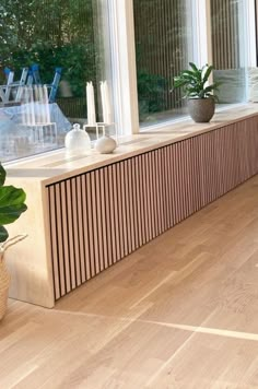 a living room filled with lots of furniture next to a window covered in plants and windowsills