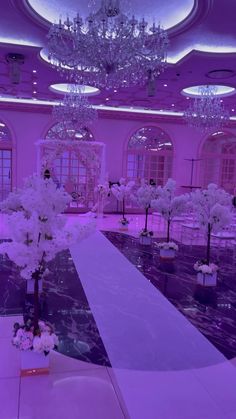 an empty ballroom with chandeliers and flowers on the floor