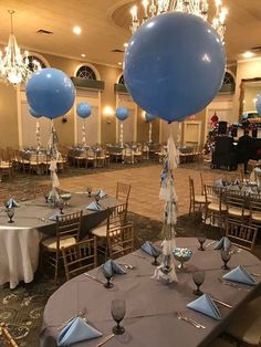 blue balloons are on top of tables at a party