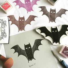 some bats are laying on top of a sheet of paper next to markers and ink