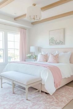 a white bedroom with pink and white decor