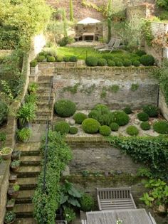 an aerial view of a garden with steps leading up to the top floor and trees in the background