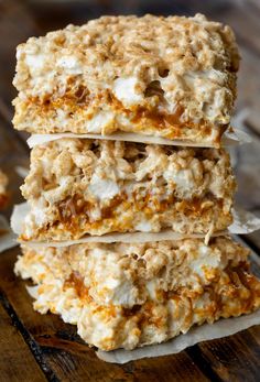 three granola bars stacked on top of each other with white frosting and caramel toppings