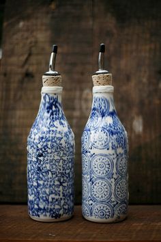 two blue and white bottles sitting on top of a wooden table