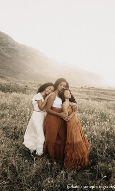 three women are standing together in a field