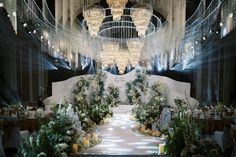 an elegant wedding setup with chandeliers and flowers on the aisle, surrounded by lights