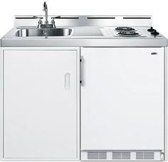 a white kitchen sink sitting next to a cabinet with a faucet on it