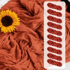 a sunflower sitting on top of a pile of red cloth