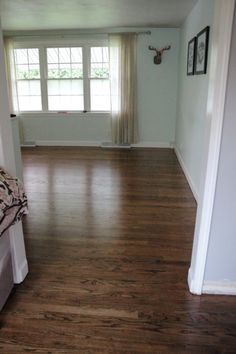 an empty bedroom with hard wood floors and white walls is seen in this image from the doorway