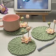 crocheted coasters with flowers on them next to a television