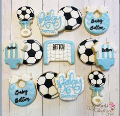 baby shower cookies decorated with soccer balls and blue icing on a wooden table top