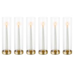 four glass candles with gold rims are lined up in a row