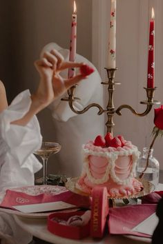 a woman sitting at a table in front of a cake with candles on top of it